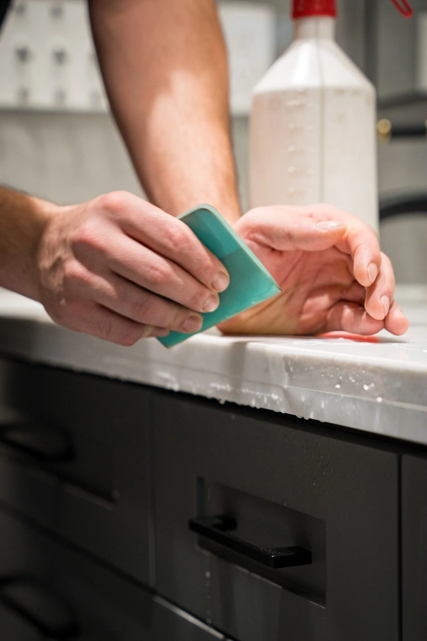 Installer using a squeegee to finish clear protection film on a countertop